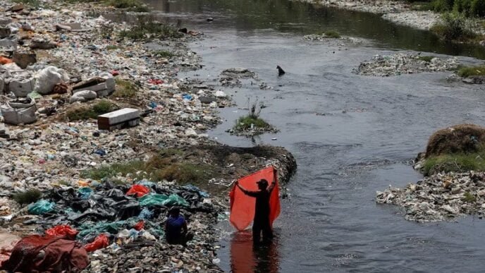 a man washes waste plastic sheets collected for recycling in the polluted waters on world environment day in karachi pakistan june 5 2023 photo reuters