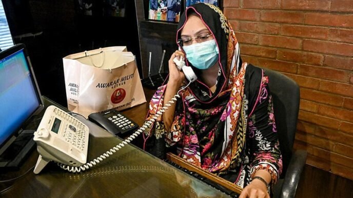 in this photograph taken on august 17 receptionist hina saleem talks on a telephone at a leather factory in karachi photo afp