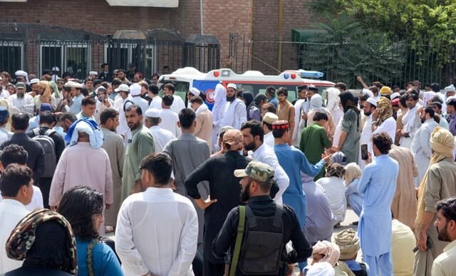 security personnel gather to protest around an ambulance carrying the body of a slain policeman who was killed along with a polio worker in an attack by gunmen in bannu on september 12 2024 photo afp