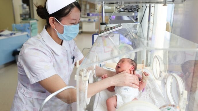 A medical staff member cares for a newborn at the neonatal care unit of a hospital in Lianyungang, East China