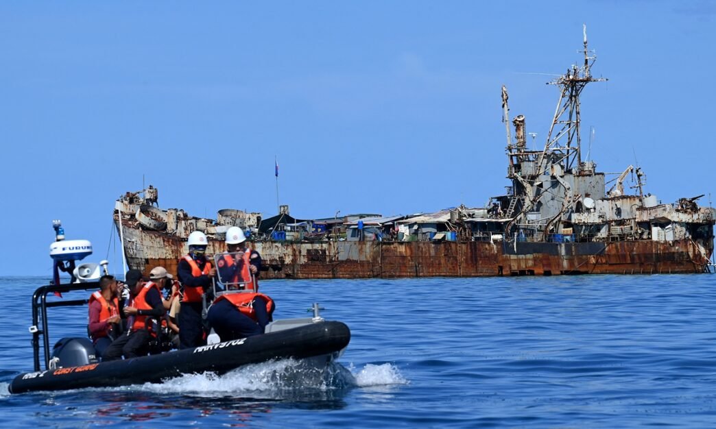 This photo taken on November 10, 2023 shows Philippine coast guard personnel and journalists sailing onboard a rigid inflatable boat (left) as they head back after filming the BRP Sierra Madre grounded at Renai Jiao in South China Sea. Photo: AFP