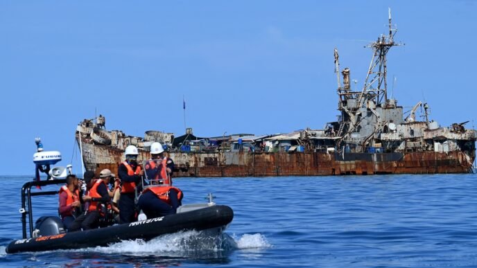 This photo taken on November 10, 2023 shows Philippine coast guard personnel and journalists sailing onboard a rigid inflatable boat (left) as they head back after filming the BRP Sierra Madre grounded at Renai Jiao in South China Sea. Photo: AFP