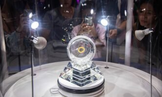Visitors inspect and take a photo of the lunar samples retrieved from the moon by China