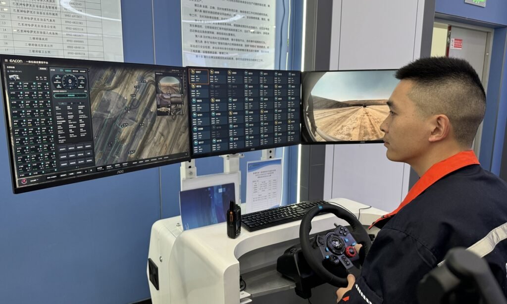 A safety inspector monitors driverless truck operations from the control room at the Shitoumei No.1 open-pit coal mine in Hami, Northwest China